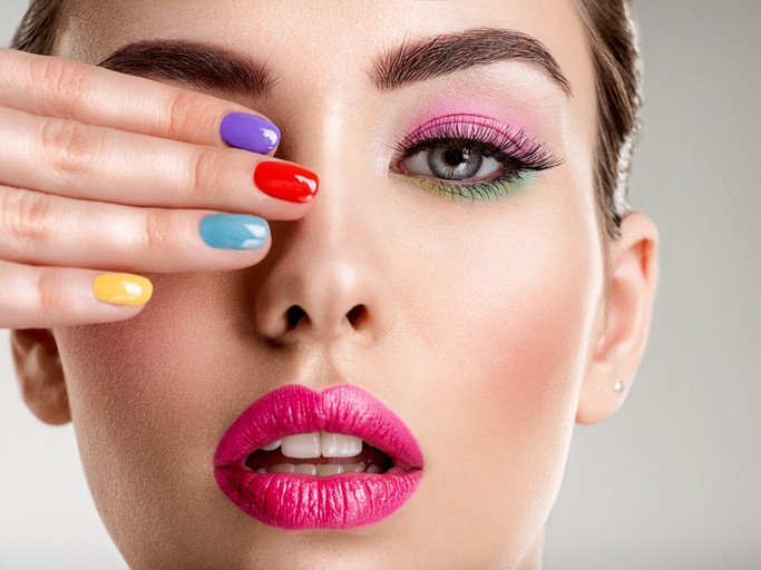 Beautiful fashion woman with a colored nails. Attractive white girl with multicolor manicure.